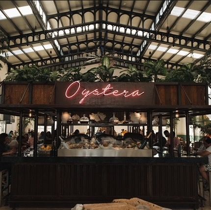 a restaurant with a neon sign that says oystera