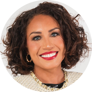 Smiling woman with curly dark hair, red lipstick, and gold hoop earrings on a white background