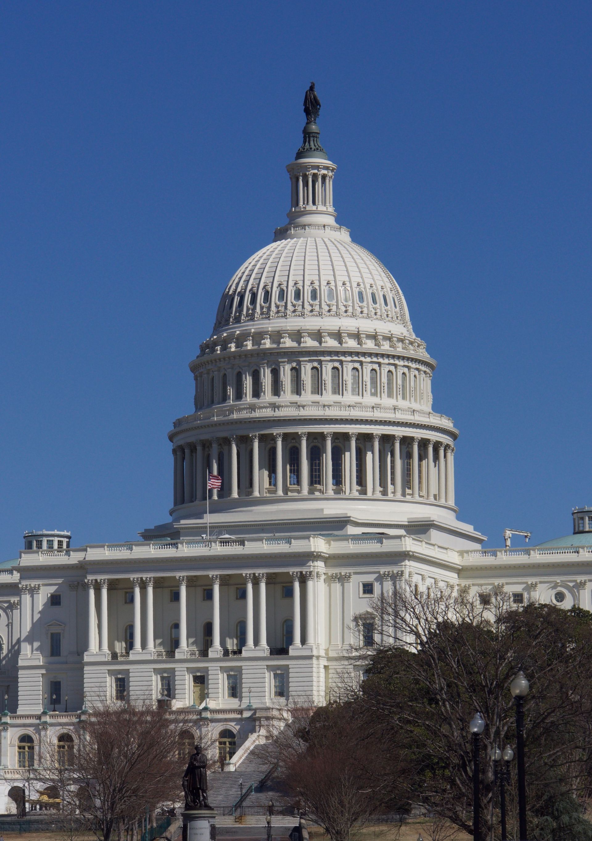 U.S. Capitol building with white dome against a clear blue sky