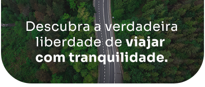 An aerial view of a road surrounded by trees with the words descubra a verdadeira liberdade de viajar com tranquilidade