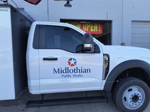 White Midlothian Public Works truck parked outside a building with an OPEN sign