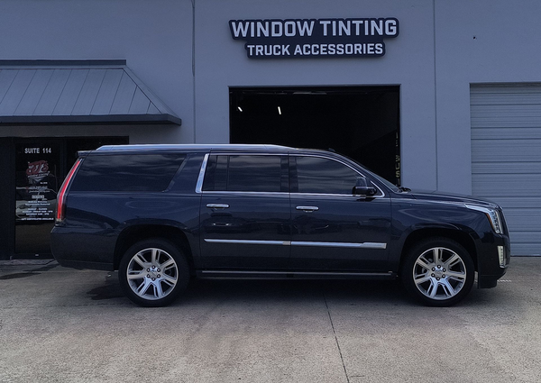 Dark blue SUV parked outside a window tinting and truck accessories shop