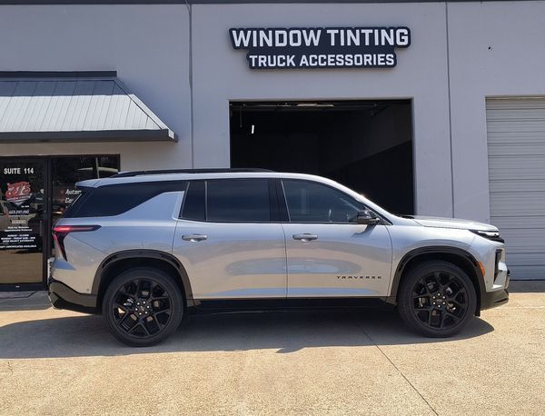 Silver SUV parked outside a window tinting and truck accessories shop