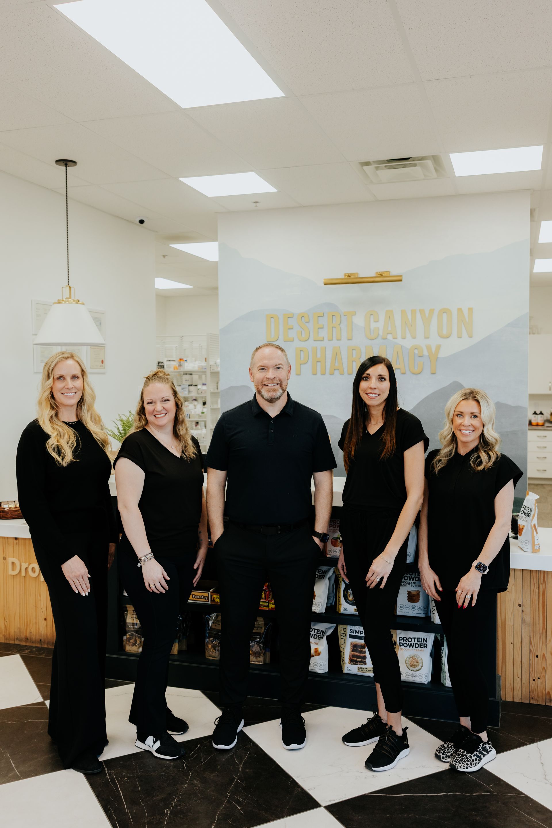 Five people in black standing in front of 