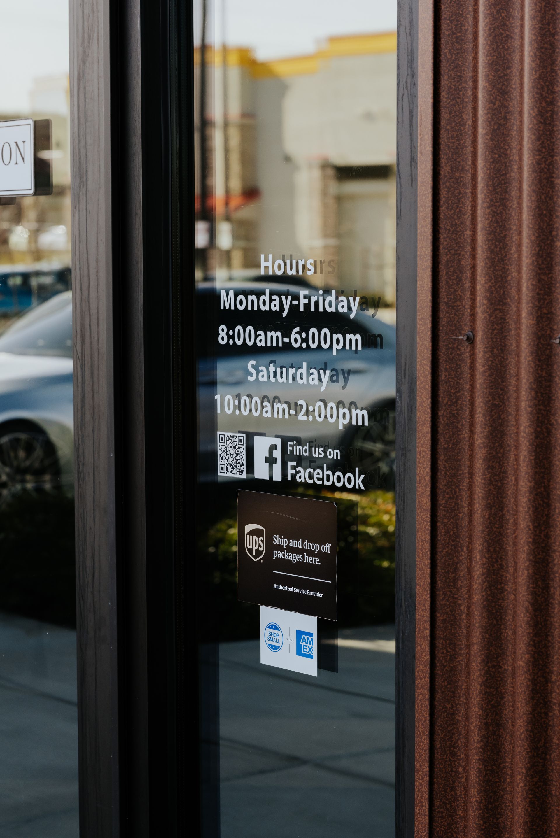 Door with store hours, Facebook logo, and UPS shipping details displayed.