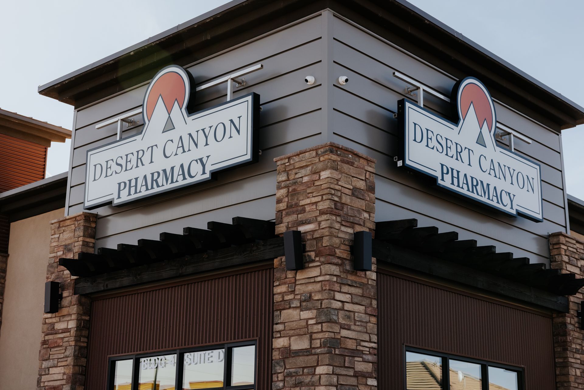 Exterior of Desert Canyon Pharmacy with signage and stone facade.