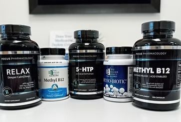 Bottles of dietary supplements: Relax, Methyl B12, 5-HTP, Pro-Biotic, and Methyl B12, on a counter.