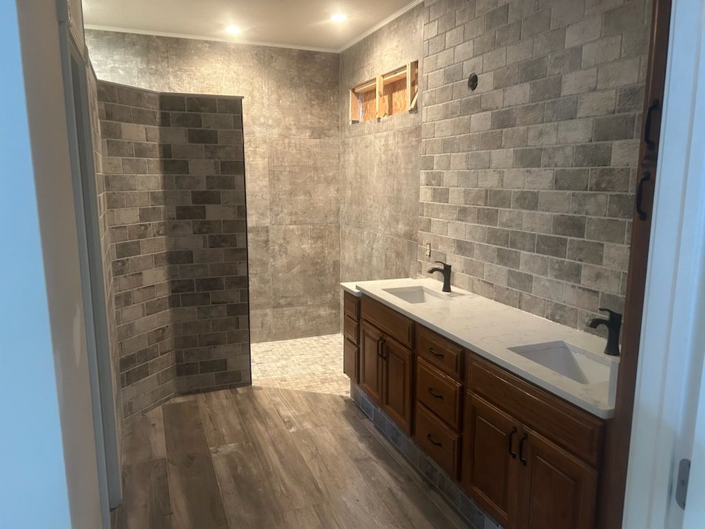 A bathroom with white brick walls and a walk in shower with a window.