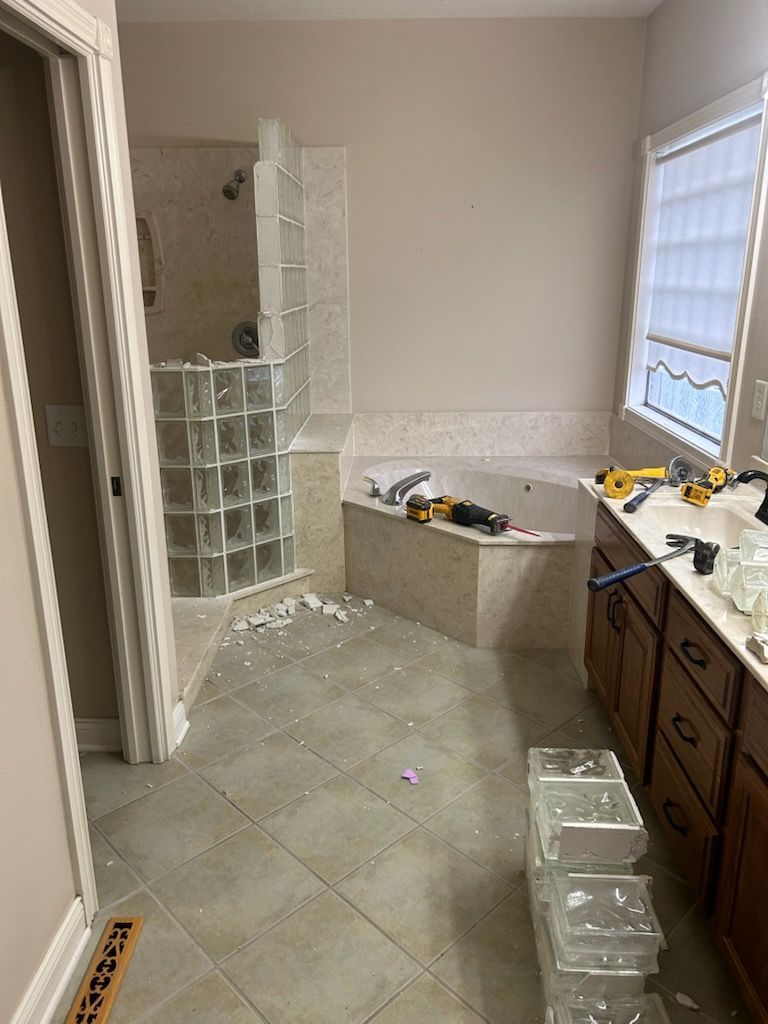 A bathroom with a tub , sink , and shower.