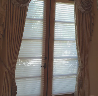 A window with blinds and curtains on it