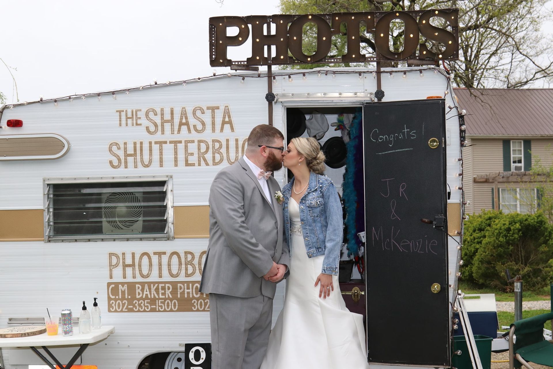 bride and groom kissing in front of photo booth