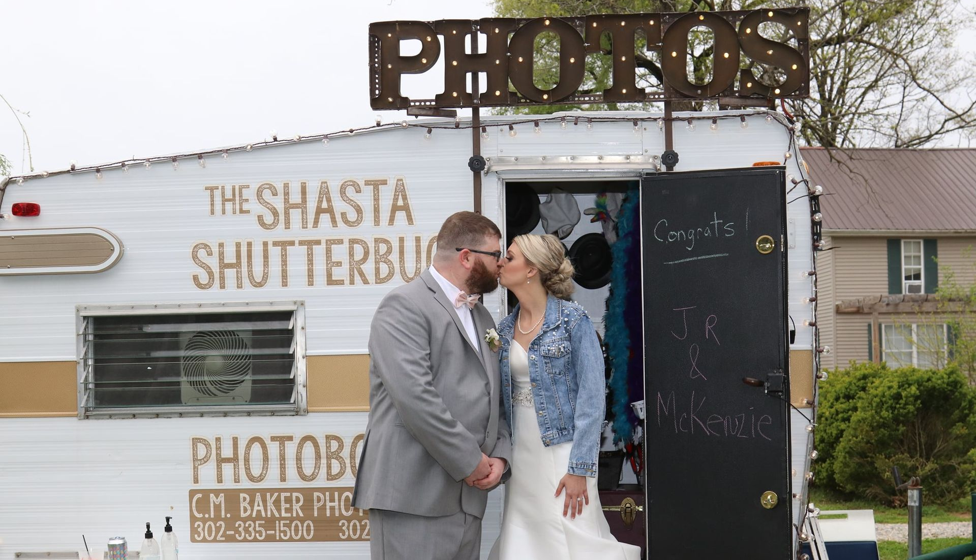 bride and groom kissing in front of vintage RV photo booth