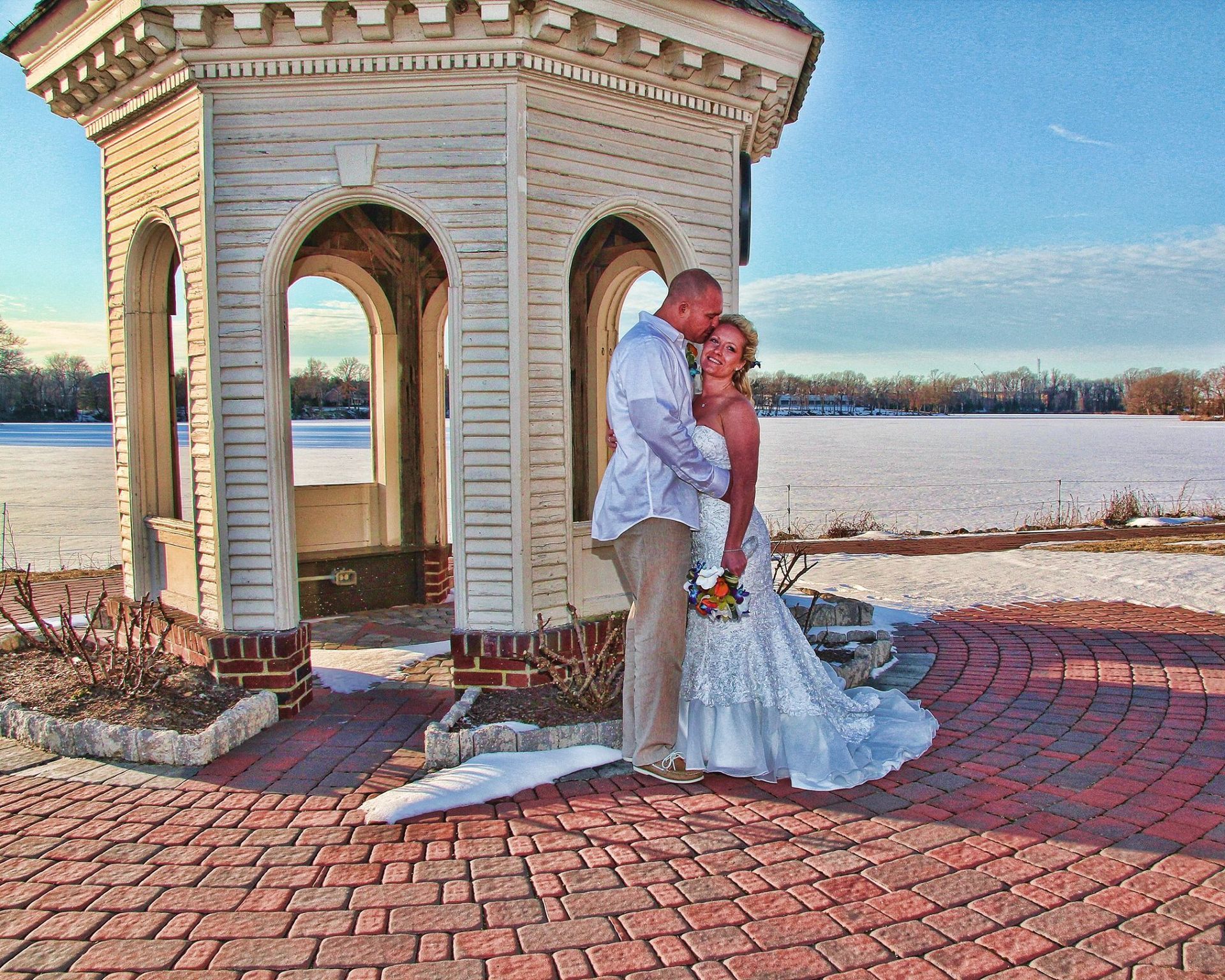 bride and groom kissing next to pergola