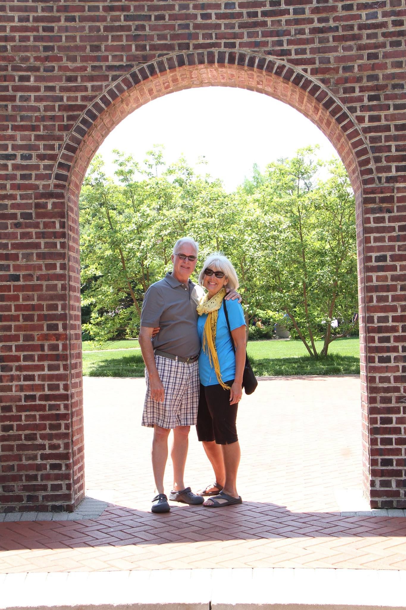 couple standing under brick arch
