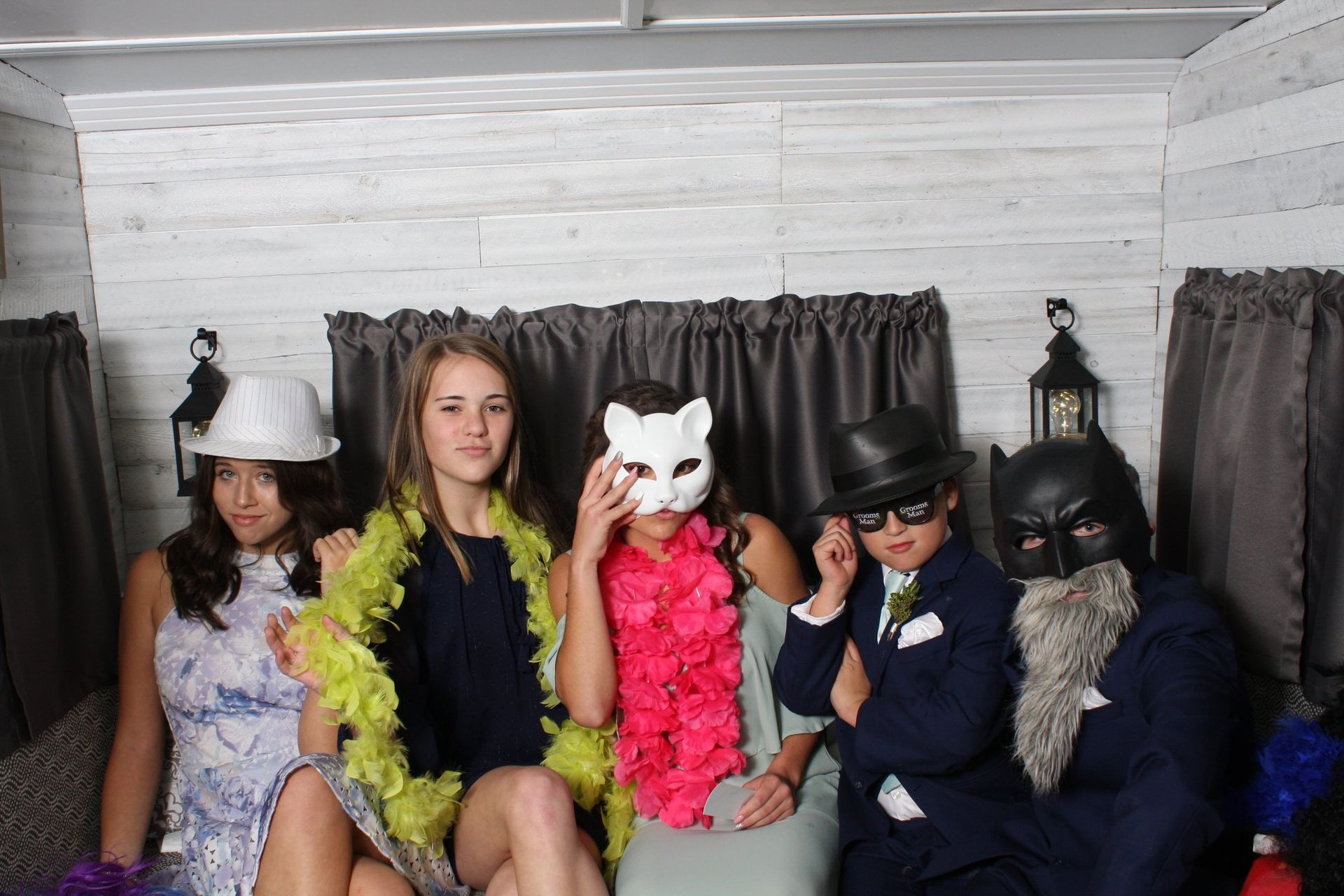 party guests posing with props in photo booth trailer