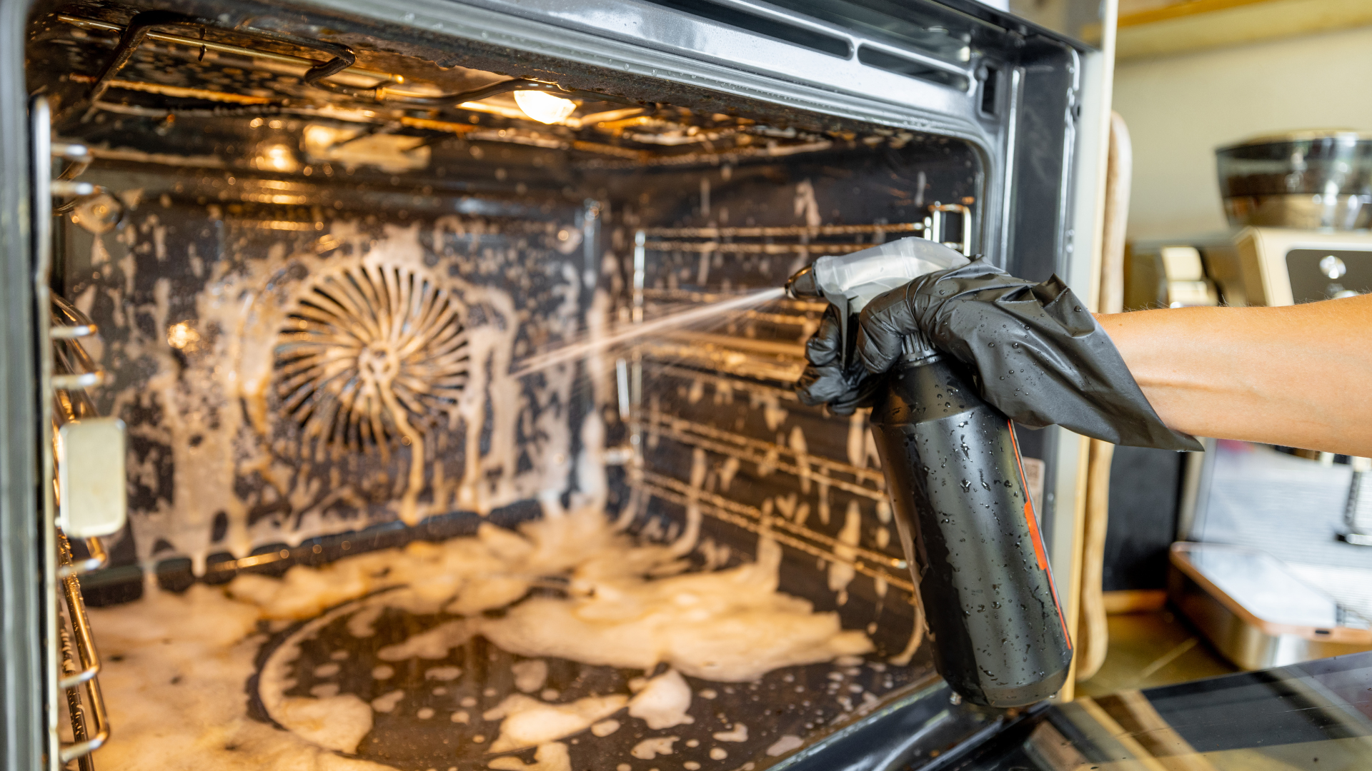 A dirty oven interior with baked-on grease and burnt residue on the walls and rack.