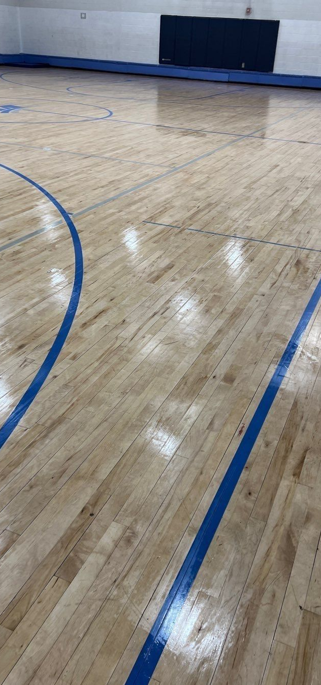 Basketball court with blue lines on the wooden floor.