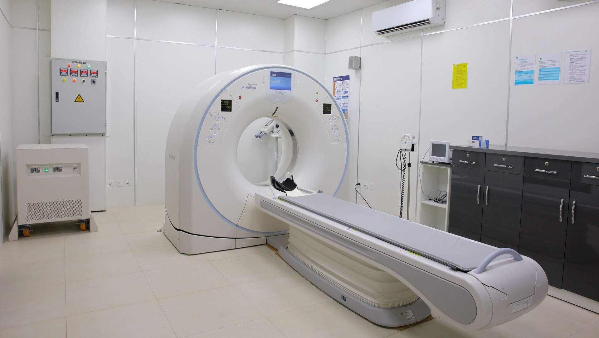 Hospital CT scanner room with a white medical imaging machine and patient table
