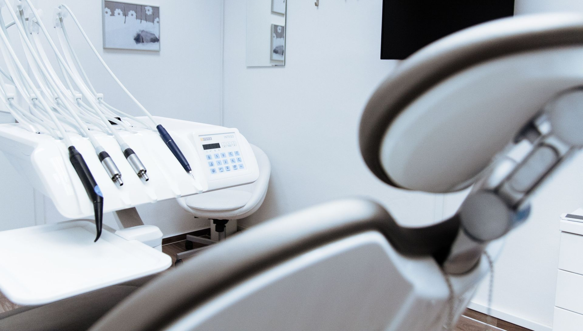 Empty dental clinic with white chairs and equipment in a clean, bright room