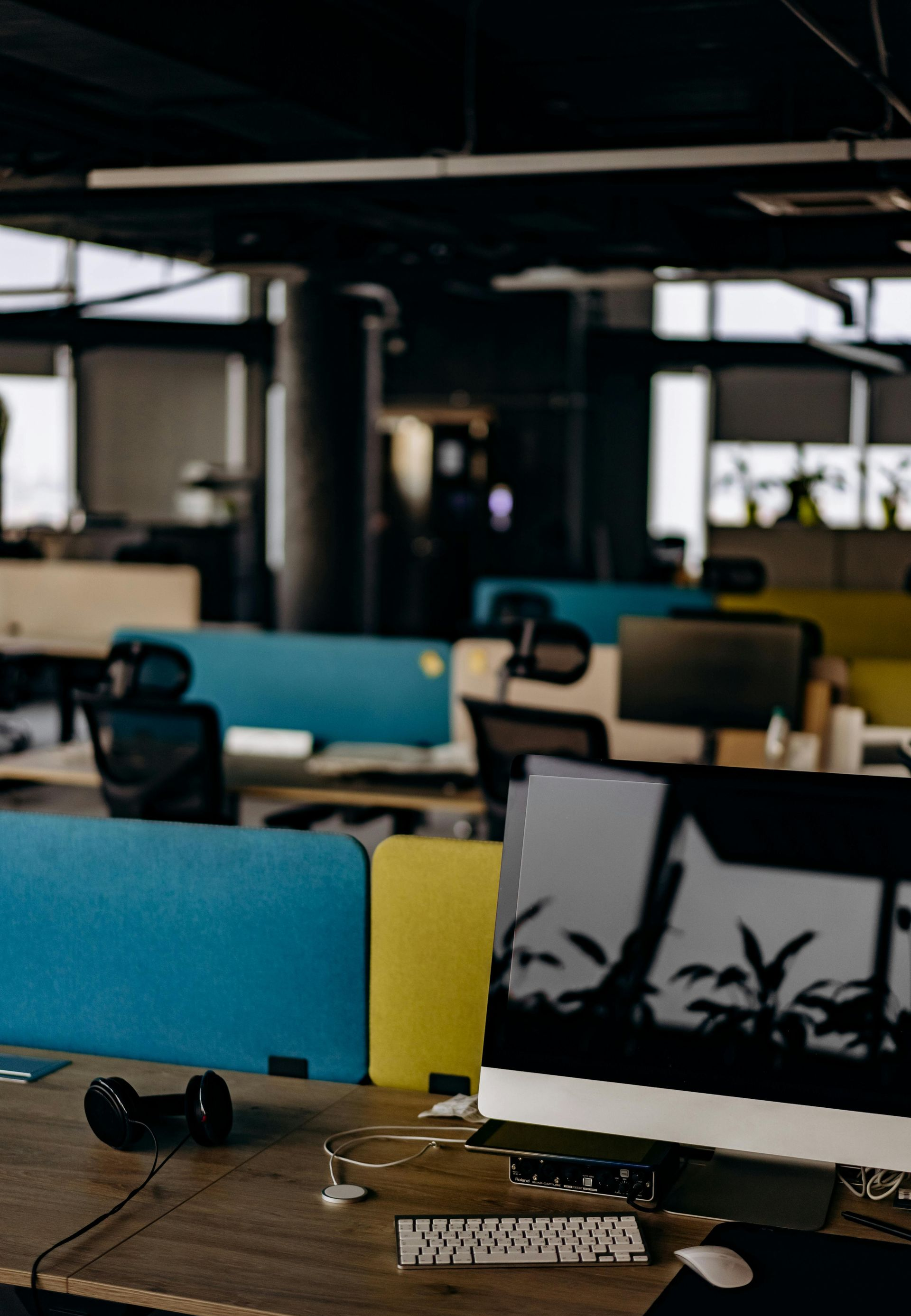 Open office with desks, computers, and blue-and-white dividers.