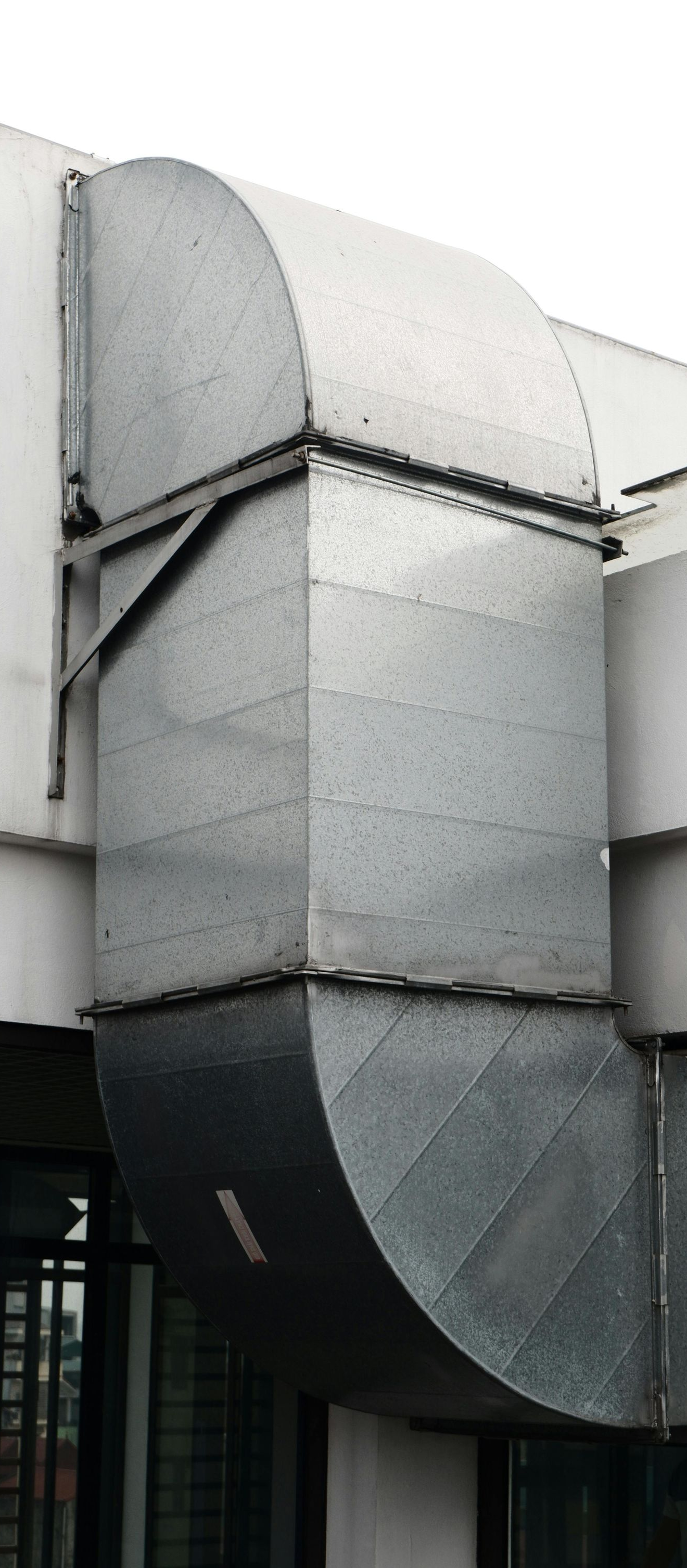 Gray metal ductwork and venting on a building exterior.