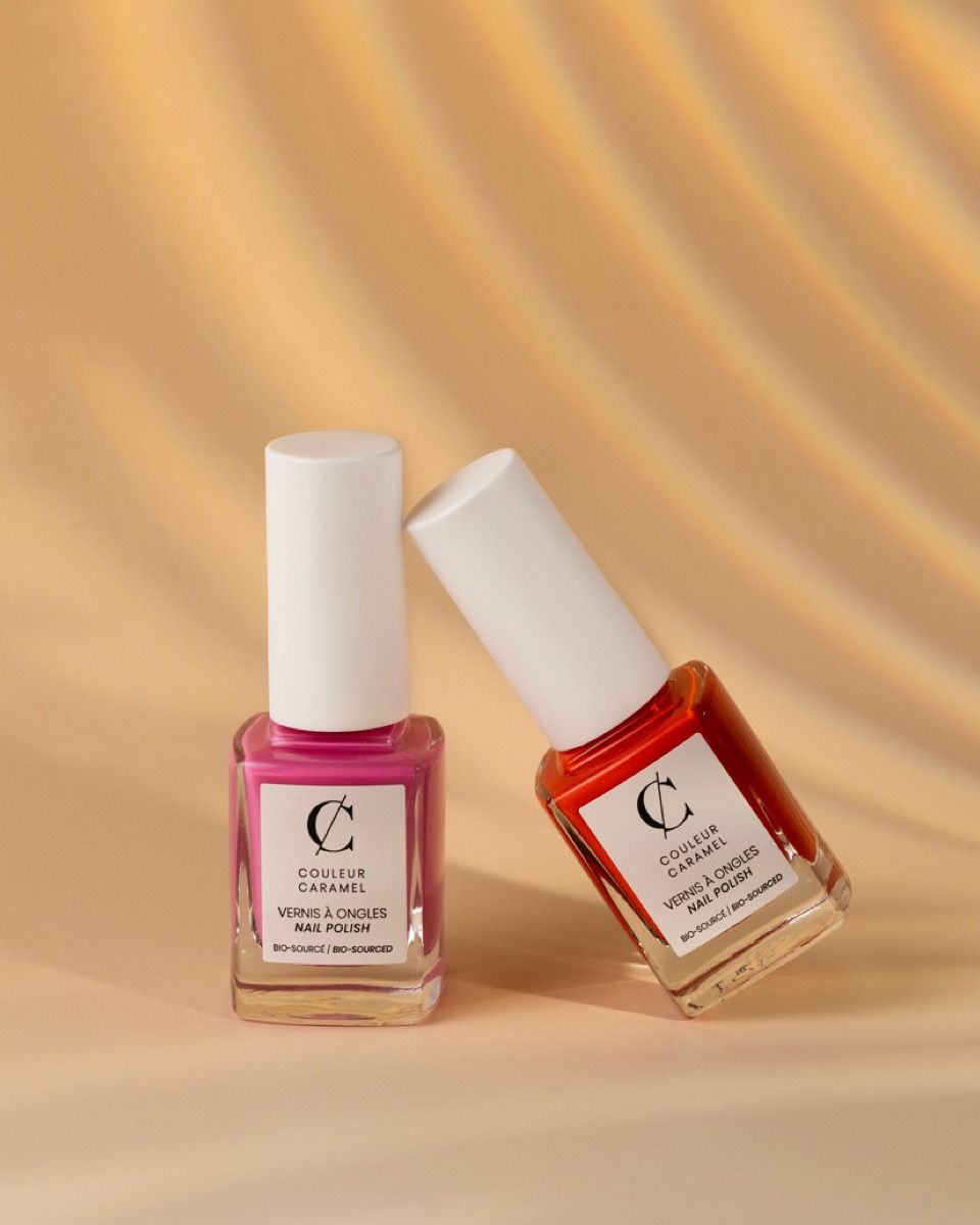 Deux bouteilles de vernis à ongles sont posées l'une à côté de l'autre sur une table.