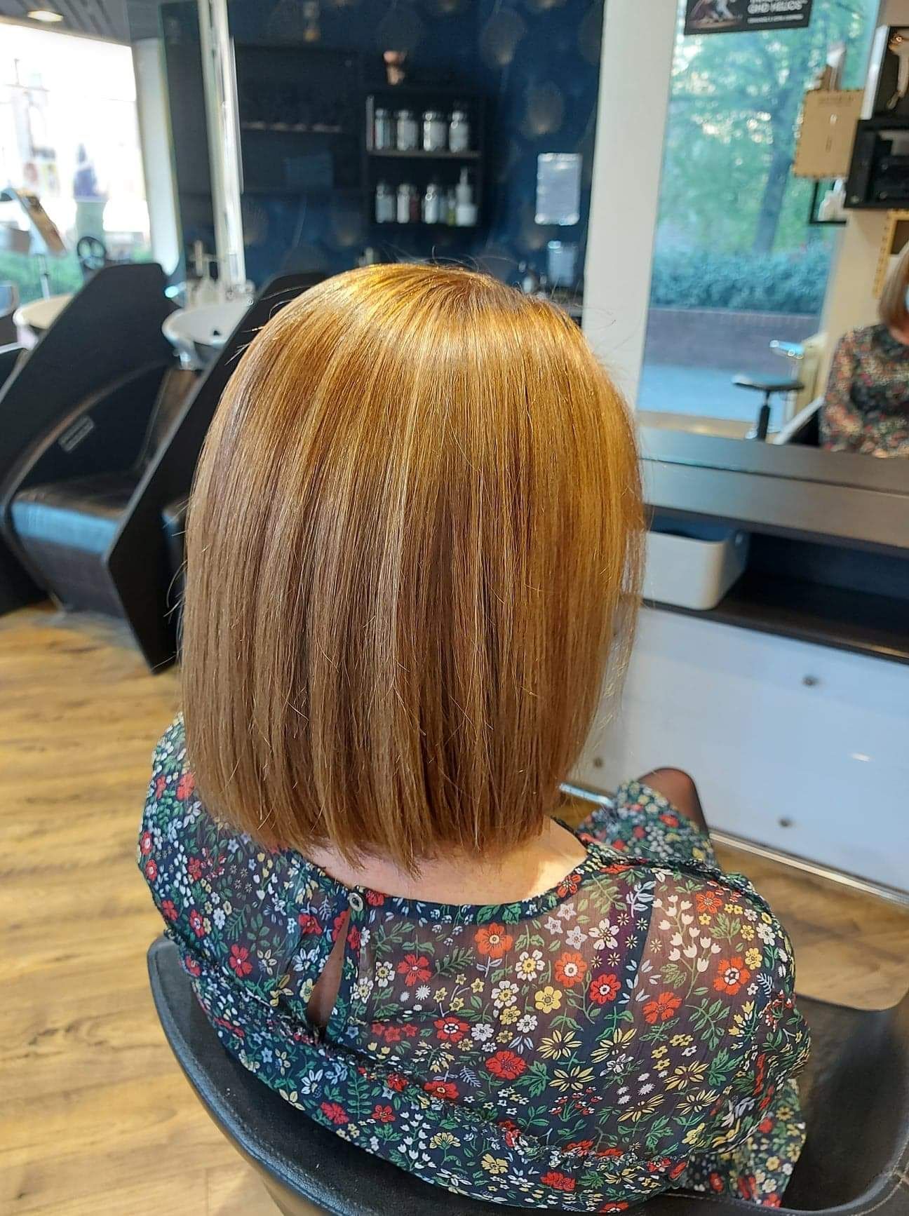 Une femme est assise sur une chaise dans un salon de coiffure.
