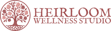 A logo for Heirloom Wellness Studio featuring a circular line-art tree with blooming flowers and the text to its right.