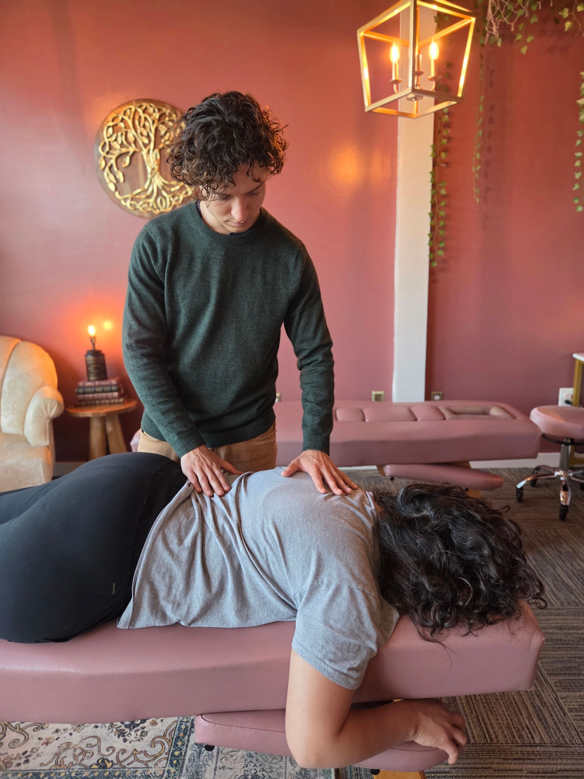 Physical therapist stretching a patient’s arm while they lie face down on a table