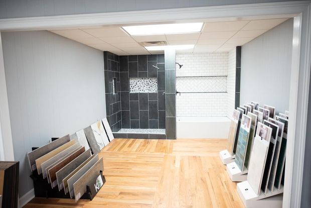 Tile showroom with hardwood floors, showcasing bathroom tile displays.