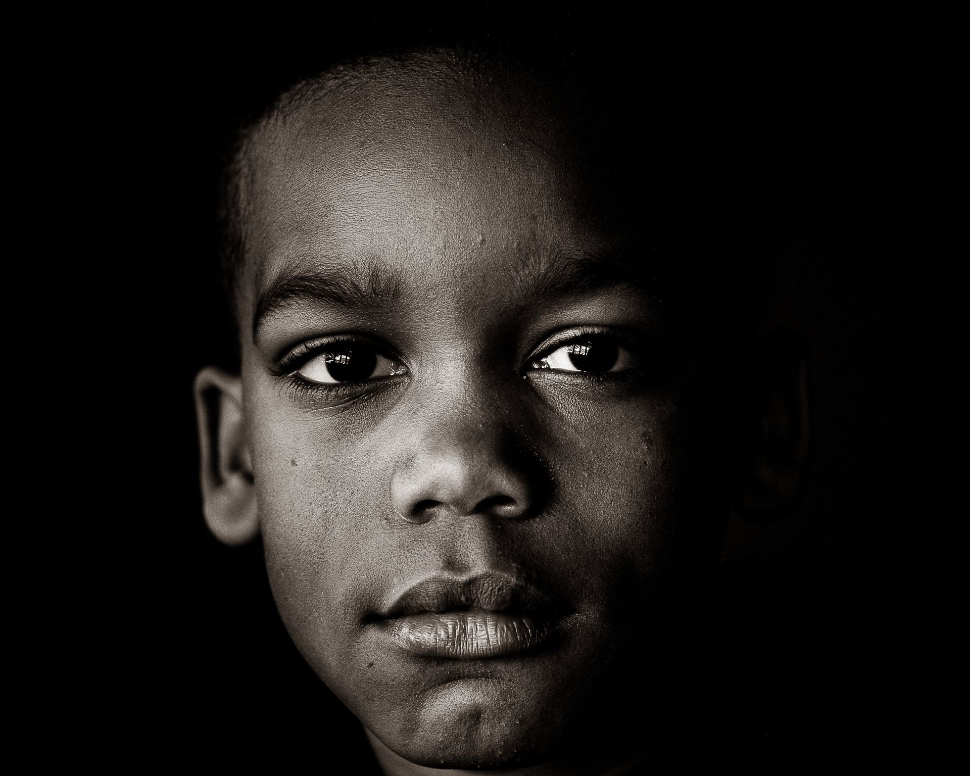 A black and white photo of a young boy 's face.