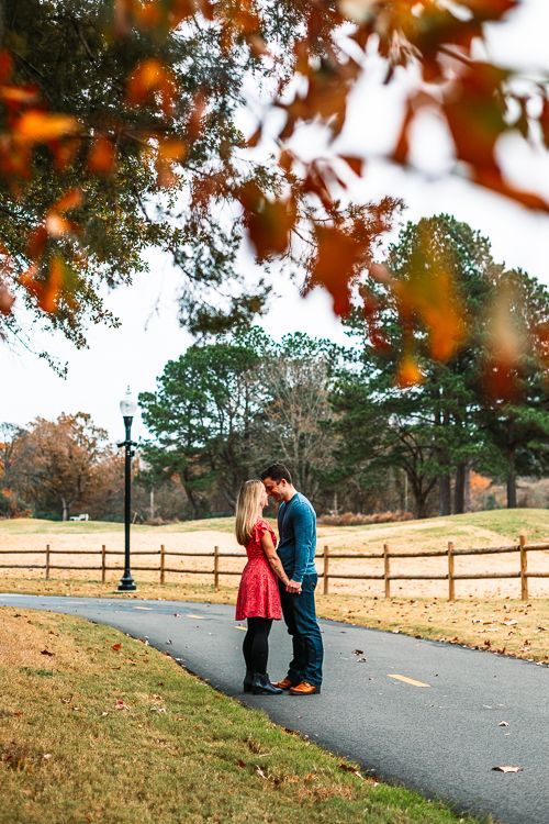 A man and a woman are kissing on the side of a road.