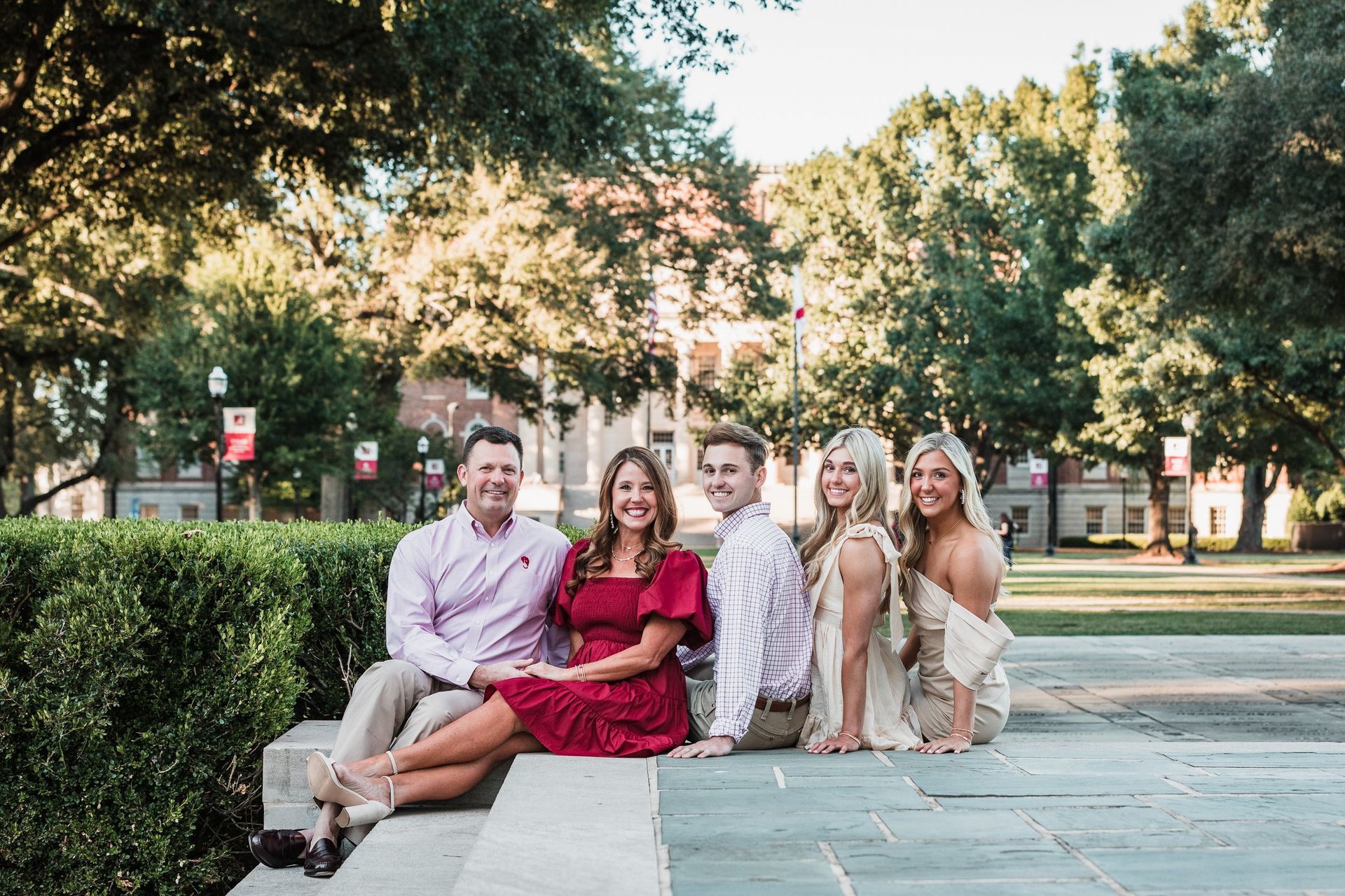 A group of people are sitting on a bench in a park.
