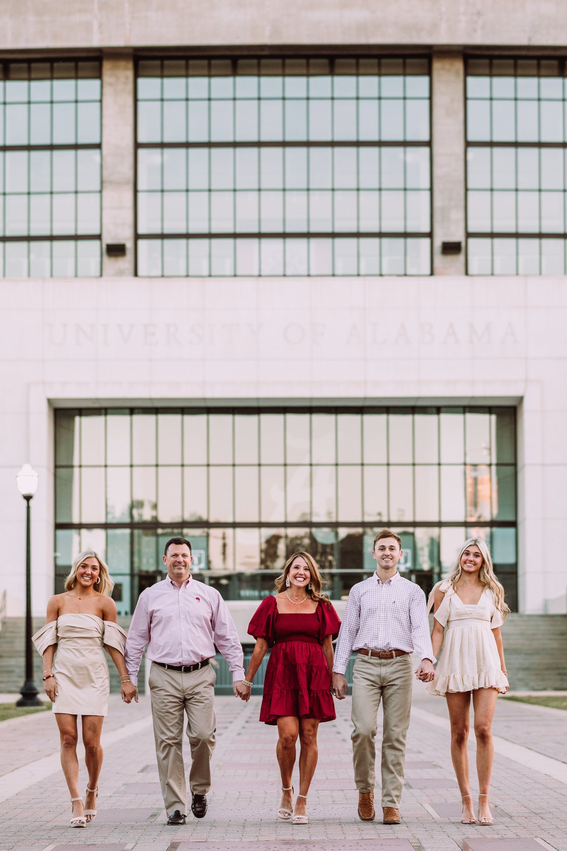 A group of people are walking in front of a building holding hands.