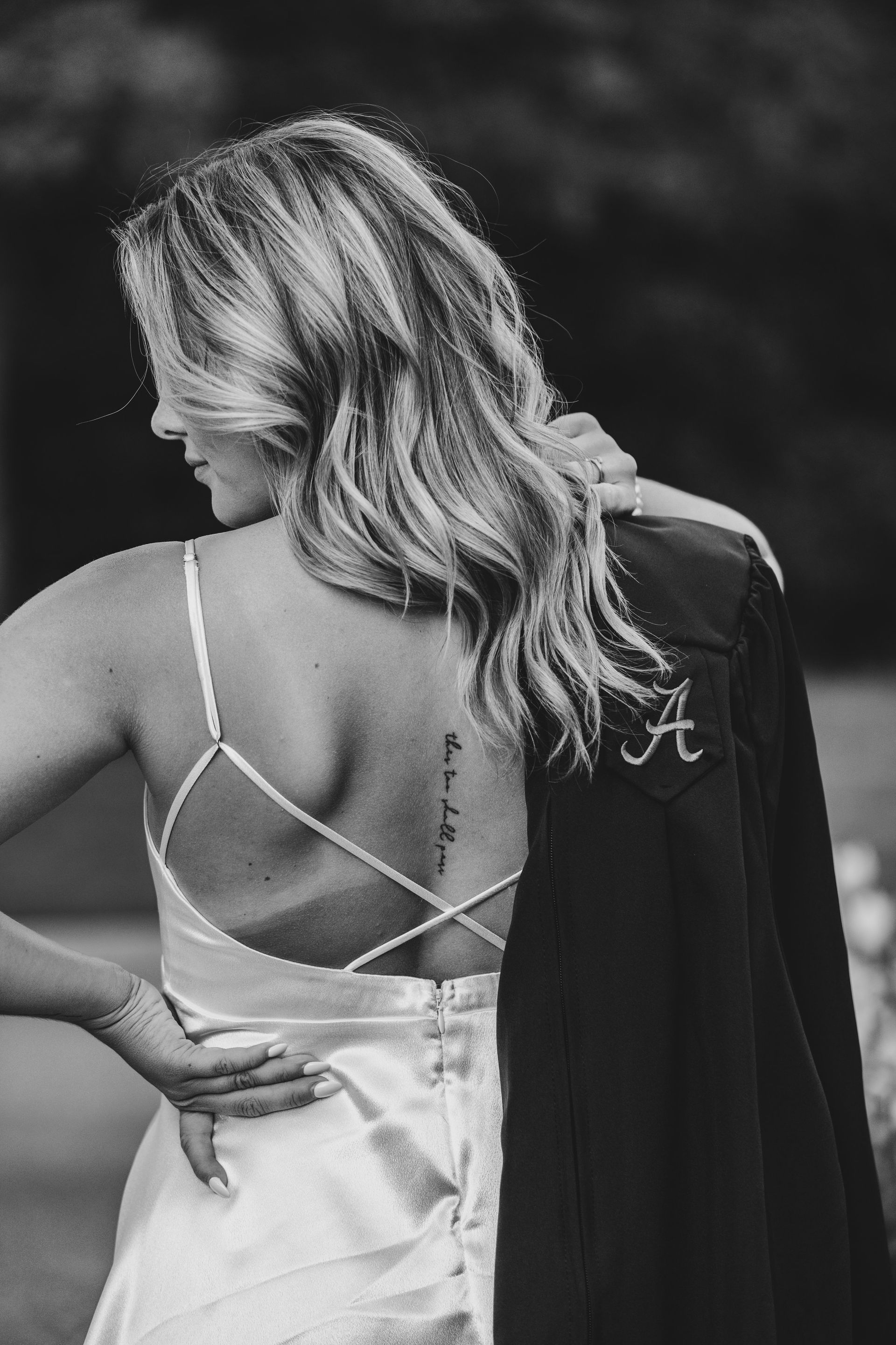 A woman in a wedding dress has a tattoo on her back.