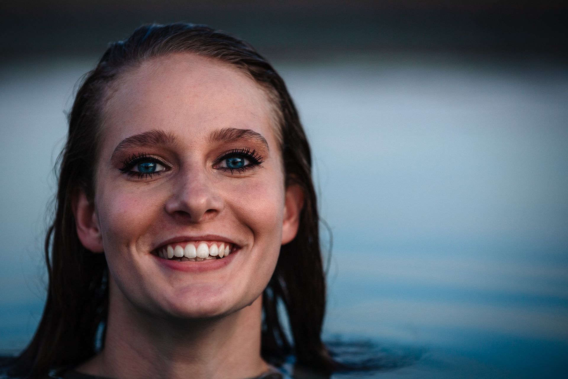 A close up of a woman smiling in a pool.