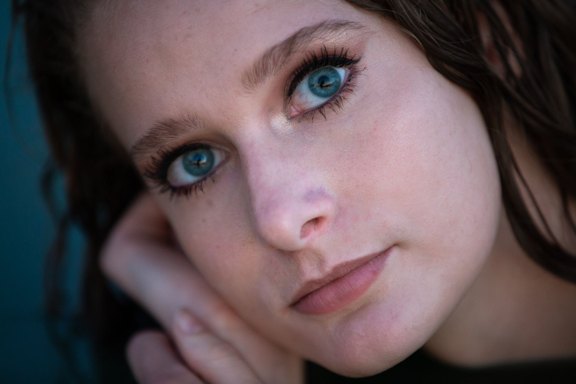 A close up of a woman 's face with blue eyes.