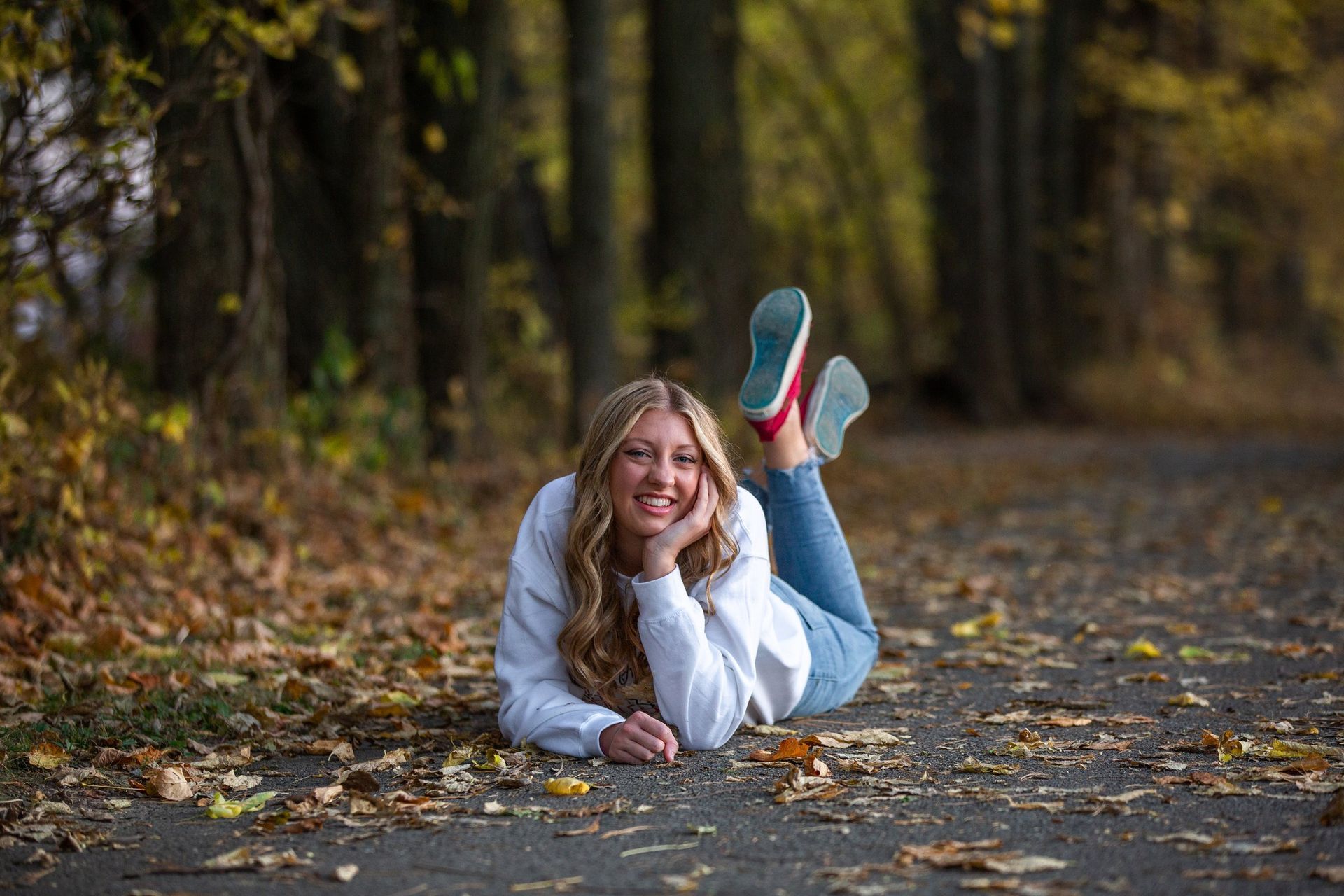 A young woman is laying on the ground with her feet up in the air.