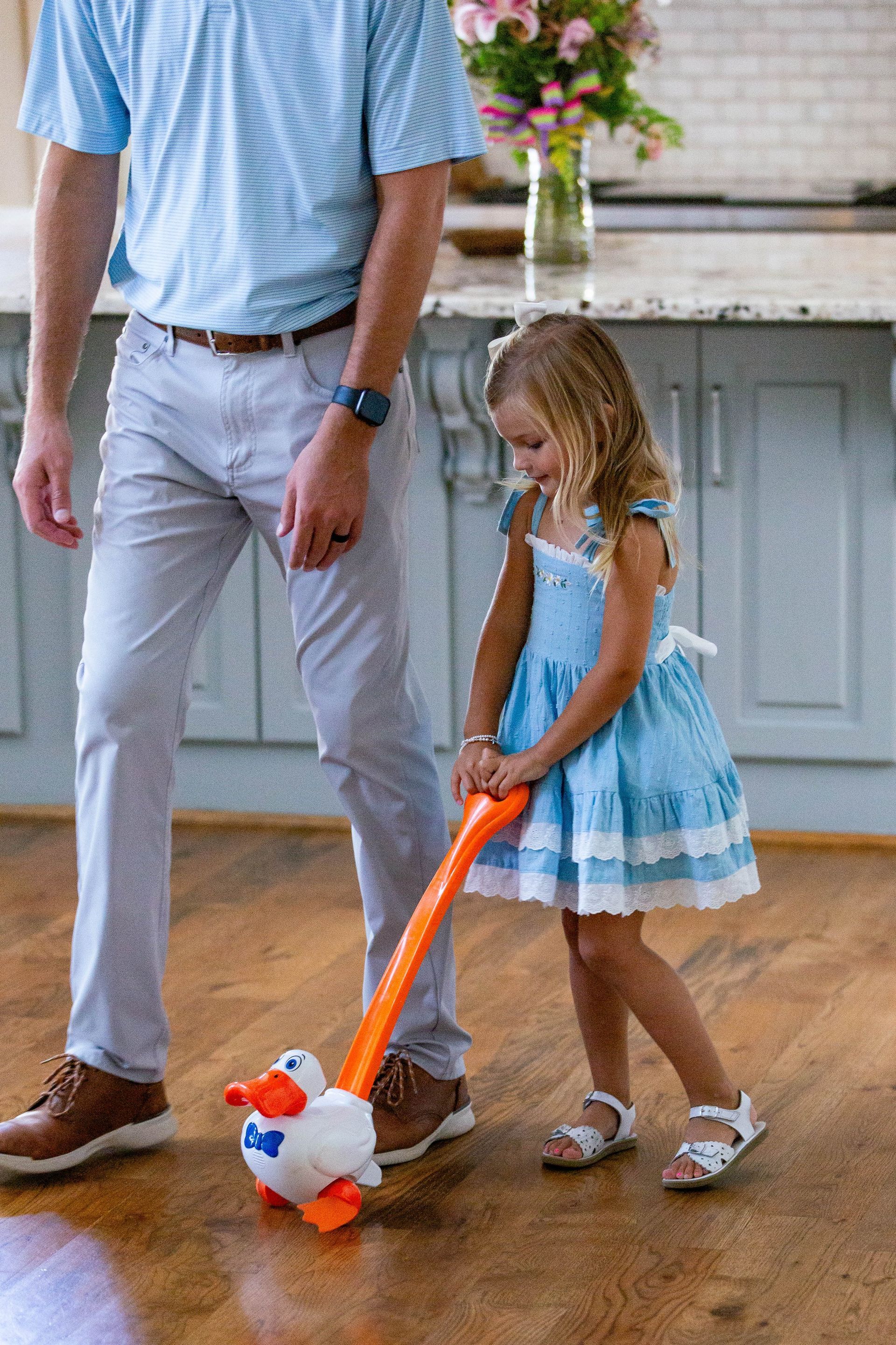 A man and a little girl are playing with an inflatable duck.