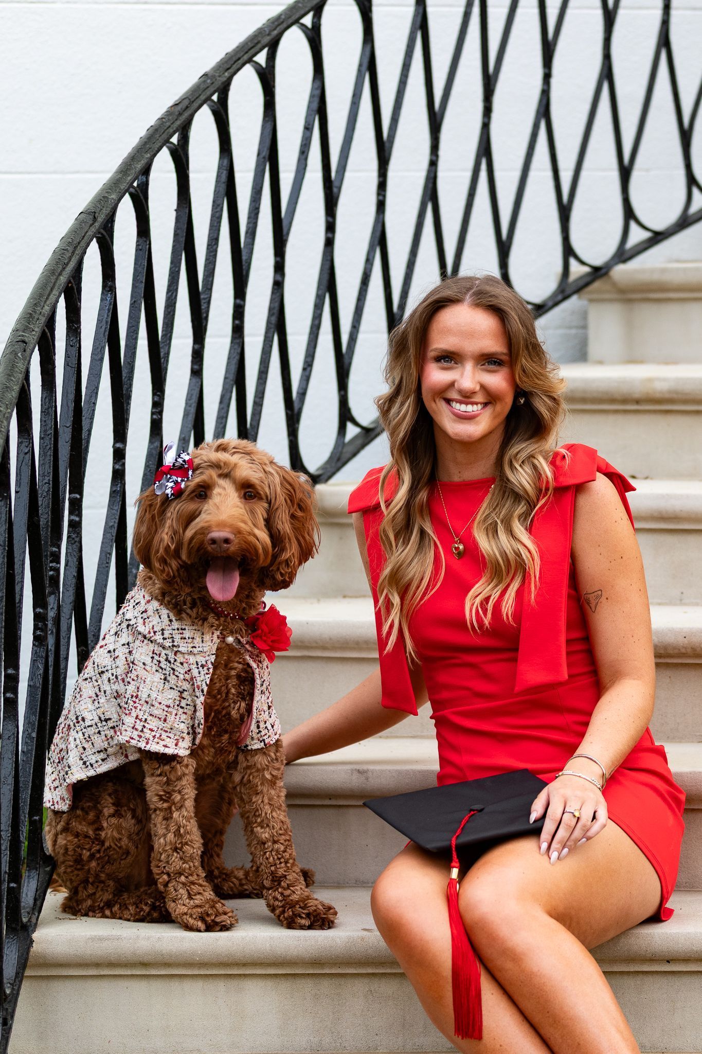 A woman is sitting on a set of stairs next to a dog.
