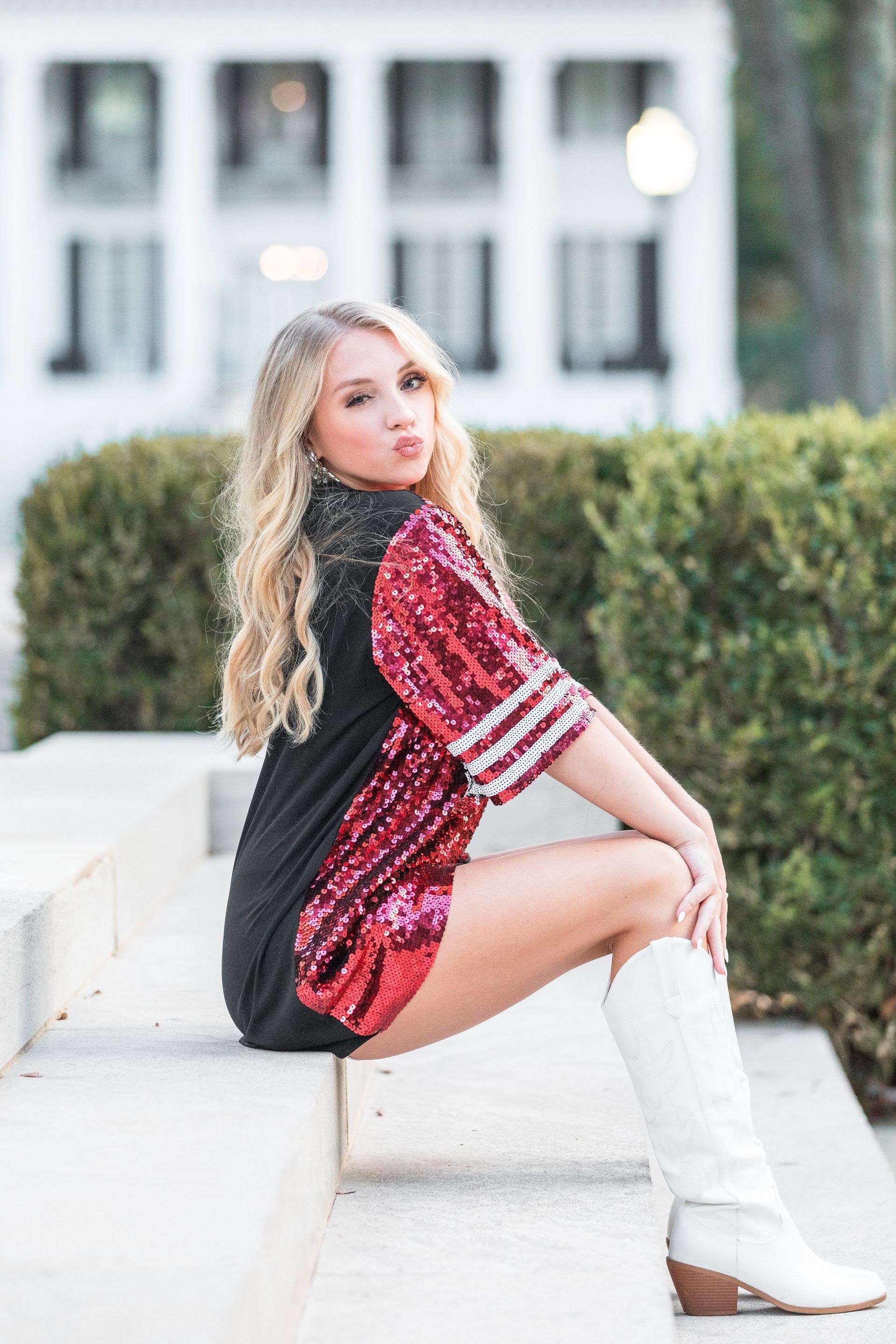 Graduation of a young adult female sitting on steps and posing.