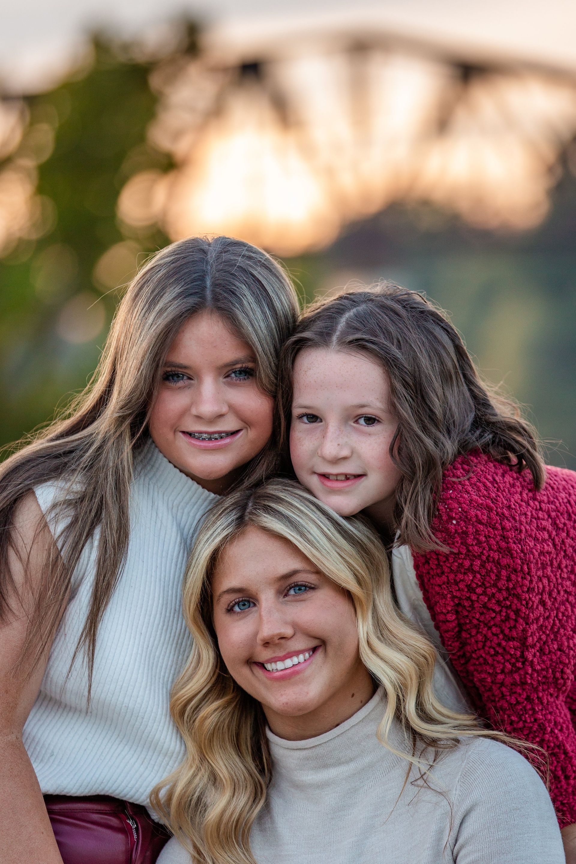 A woman and two young girls are posing for a picture.