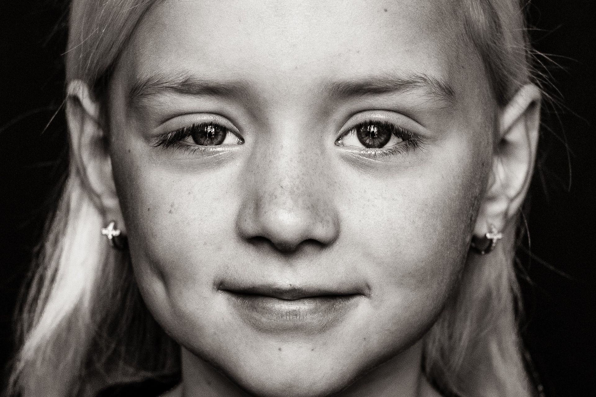 A close up of a young girl 's face in a black and white photo.