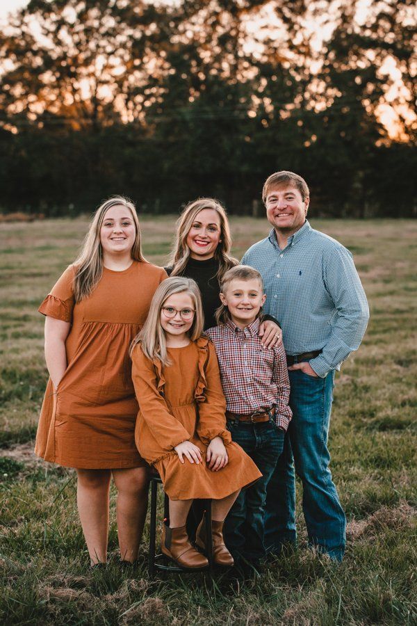 A family is posing for a picture in a field.
