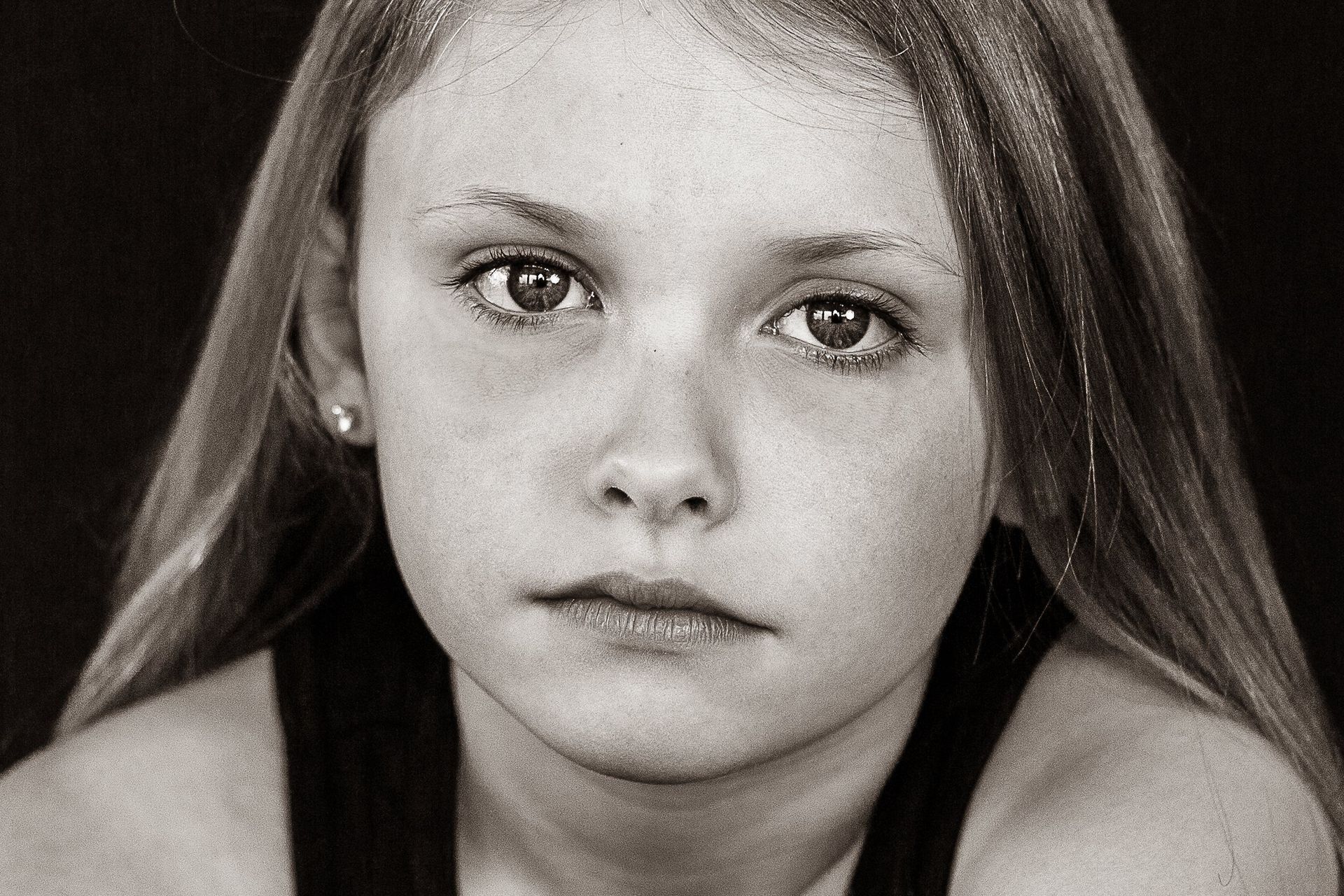 A black and white photo of a young girl looking at the camera