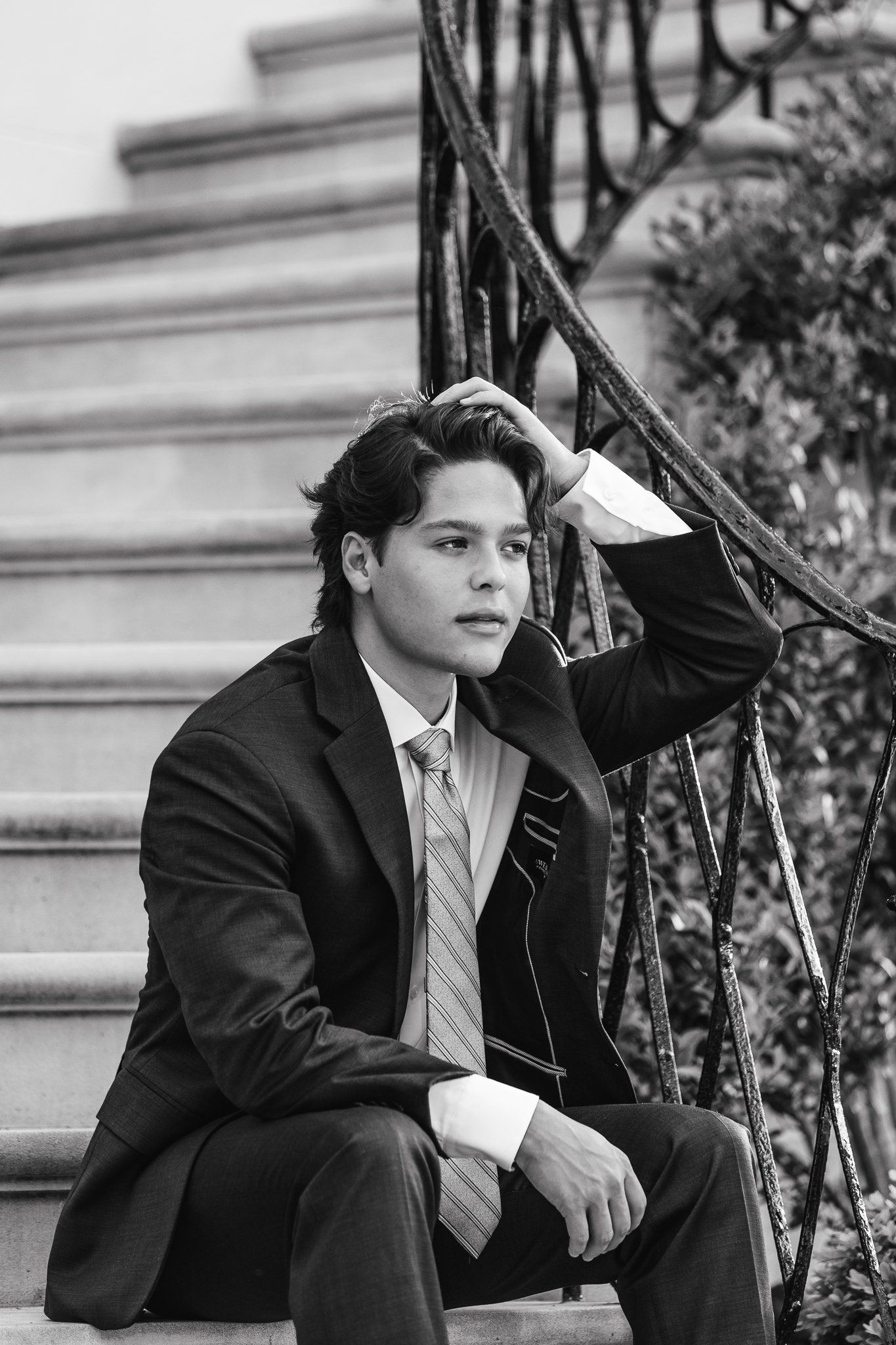 A man in a suit and tie is sitting on a set of stairs.