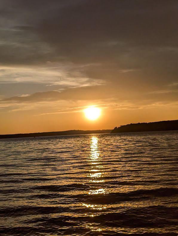 Sunset over Lake Gaston, with a golden reflection and dark shoreline silhouettes.