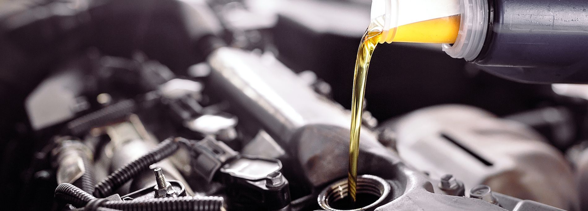 Pouring oil into a car engine.