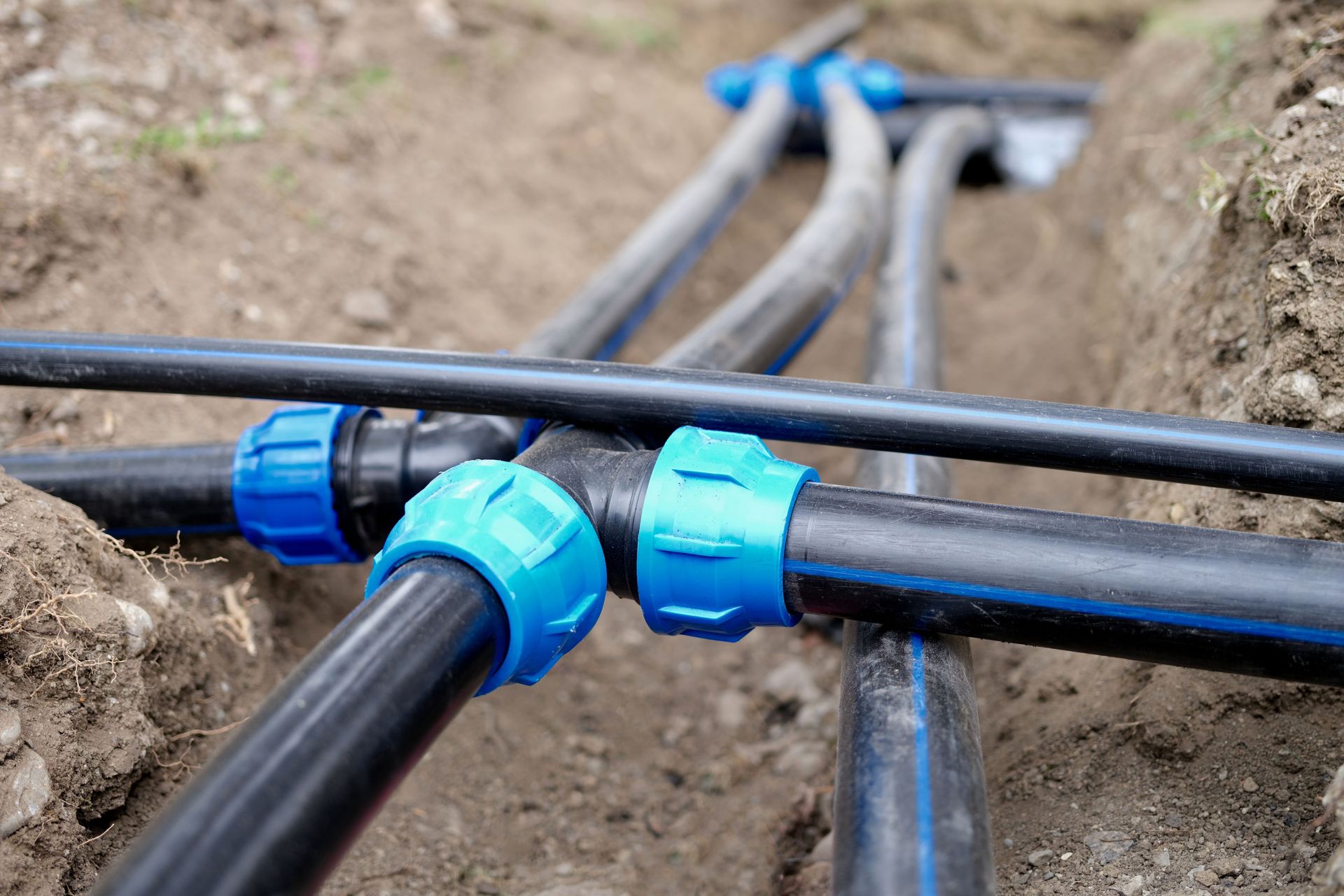 A bunch of pipes are connected to each other in the dirt.