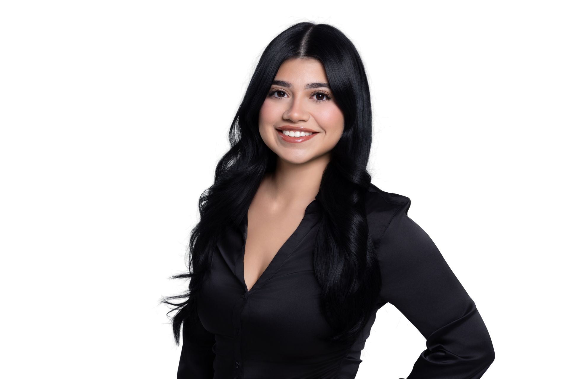 A person with long, dark hair wearing a black blouse, smiling against a plain white background.